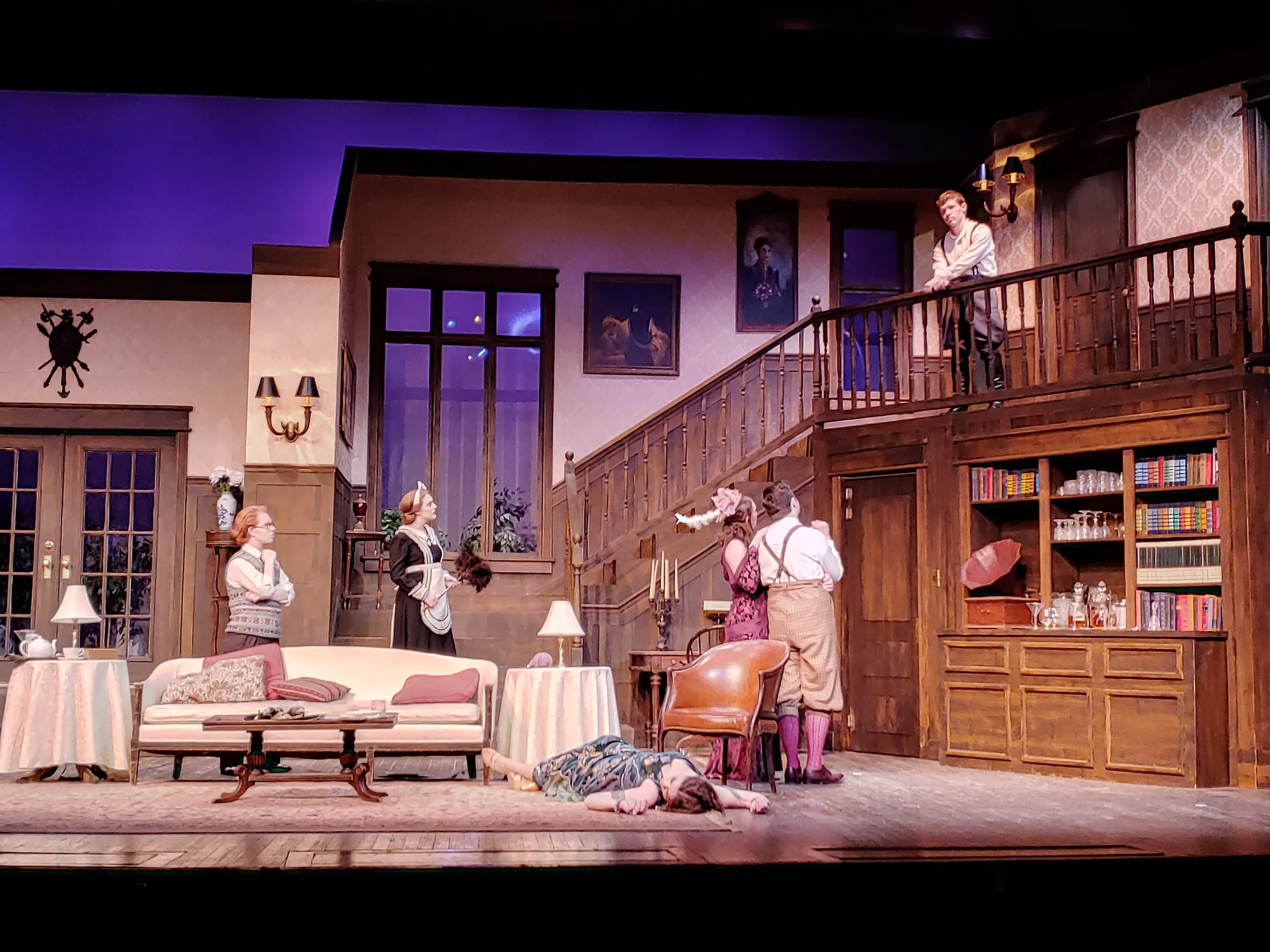 Wide view of the drawing-room set with staircase and full company