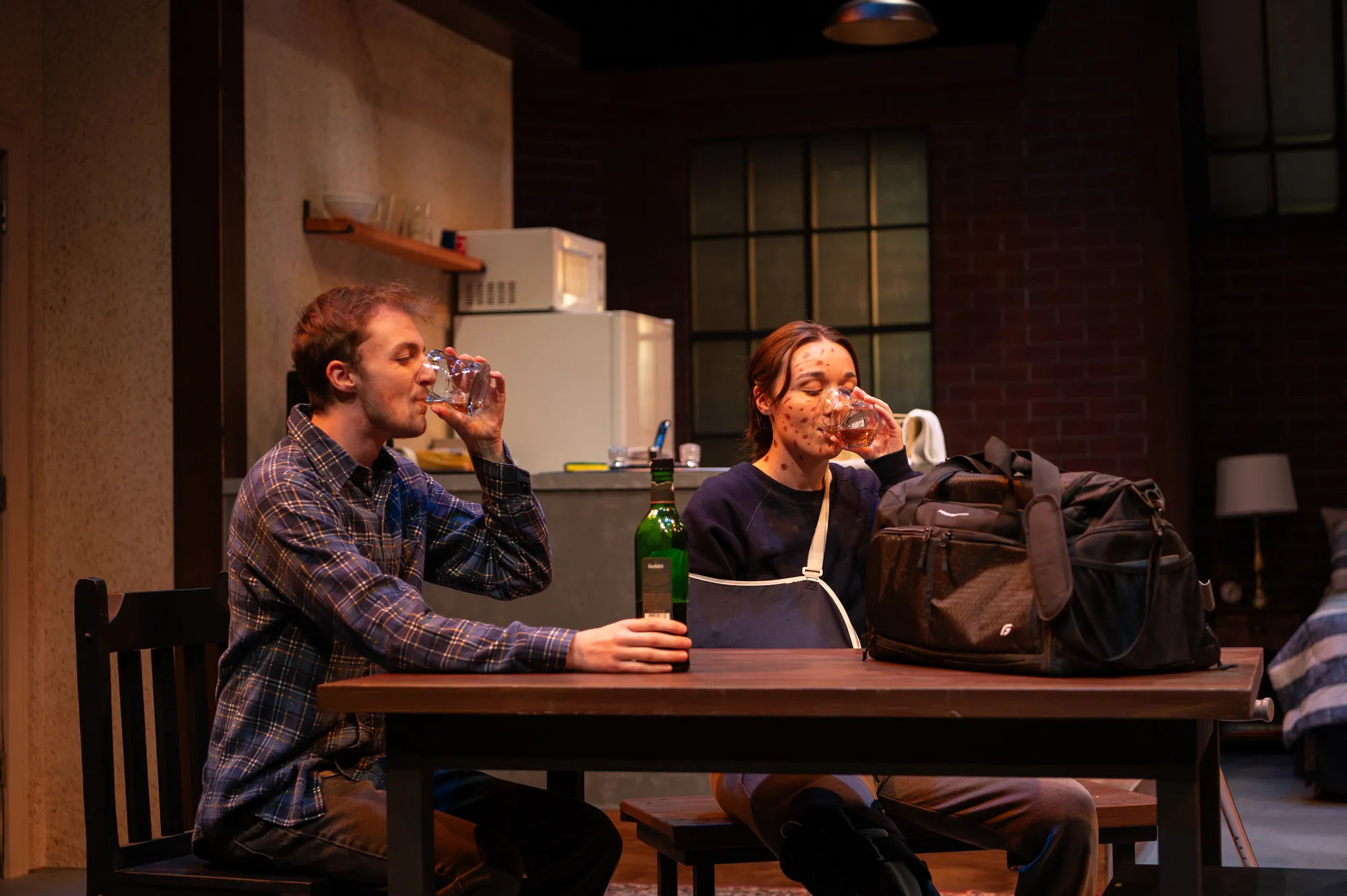 A man drinks at the table across from a woman