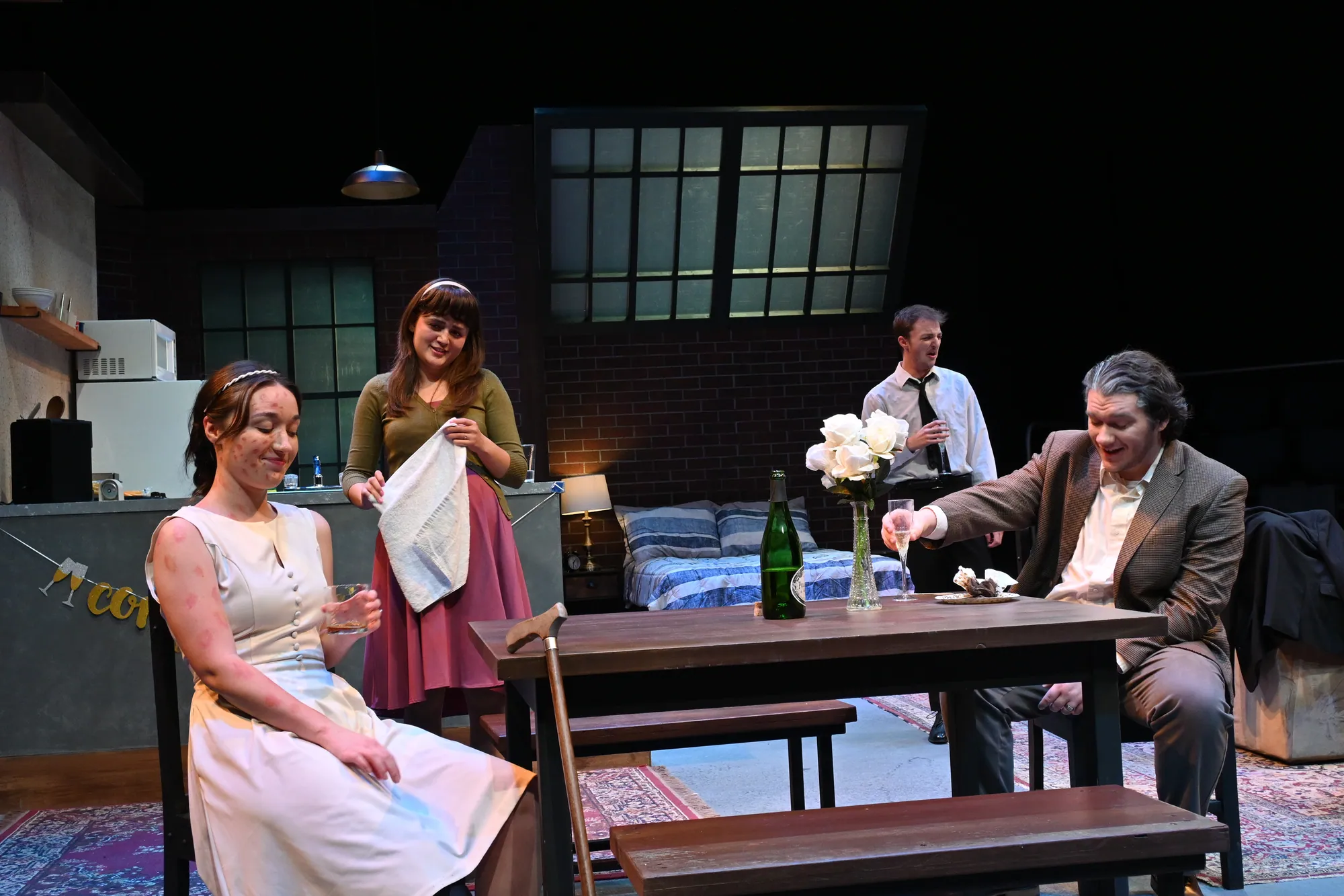 A woman in a white dress sits near a man at a table set with flowers