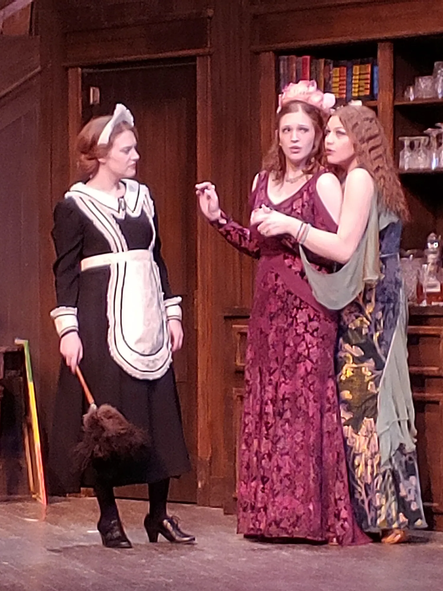 A maid and two women in period gowns