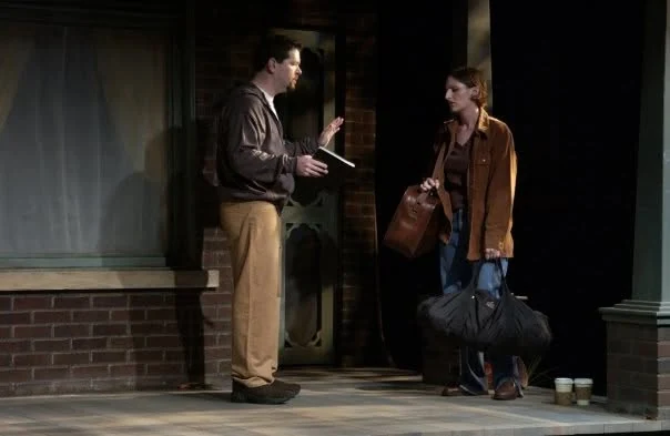 Hal, notebook in hand, pleads with a woman holding her packed bags on the porch