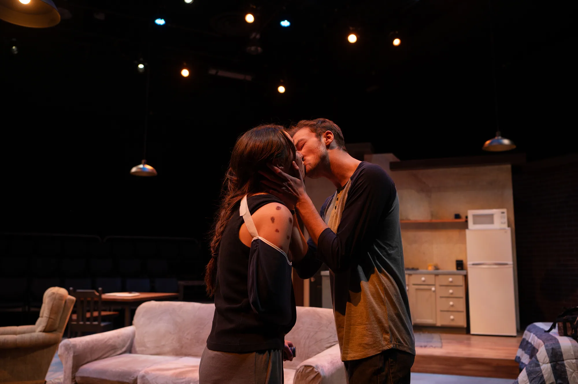A couple kisses in the kitchen of the loft apartment